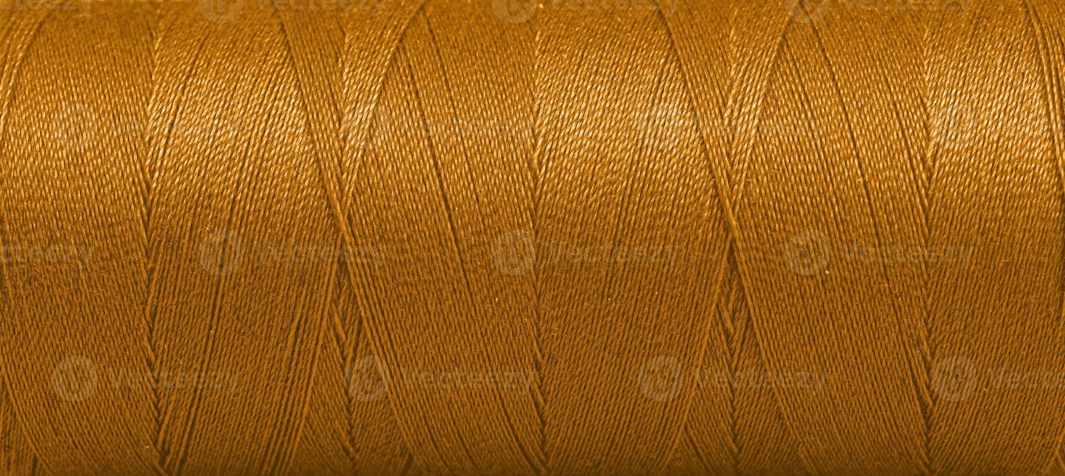 Texture of threads in a spool of brown color on a white background photo