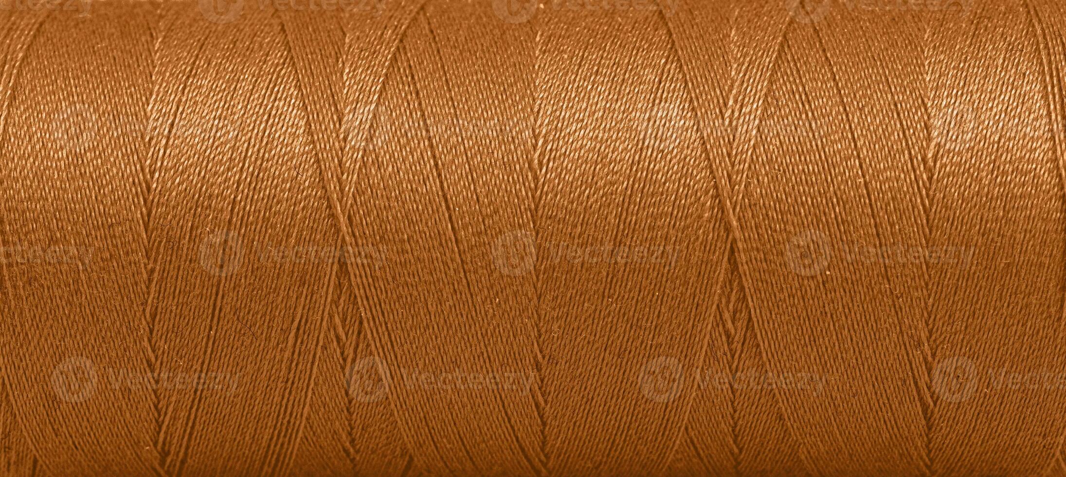 Texture of threads in a spool of brown color on a white background photo