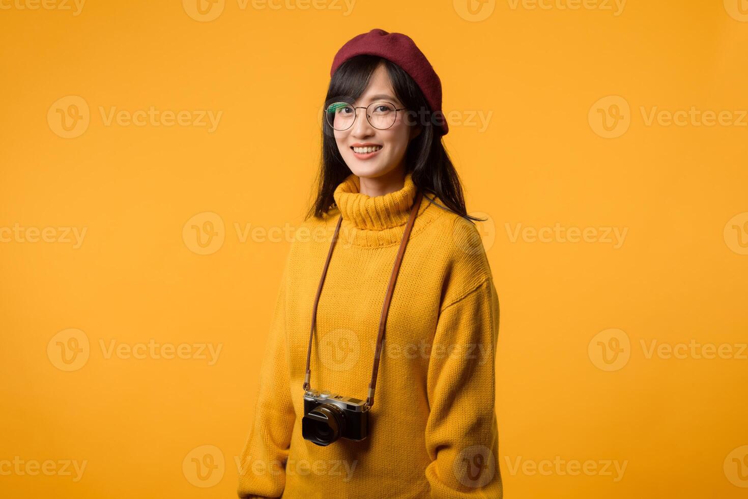 In her stylish studio, a young Asian woman, donning a yellow sweater and red beret, takes a retro portrait using her beloved camera, reminiscent of 20s and 30s nostalgia. photo