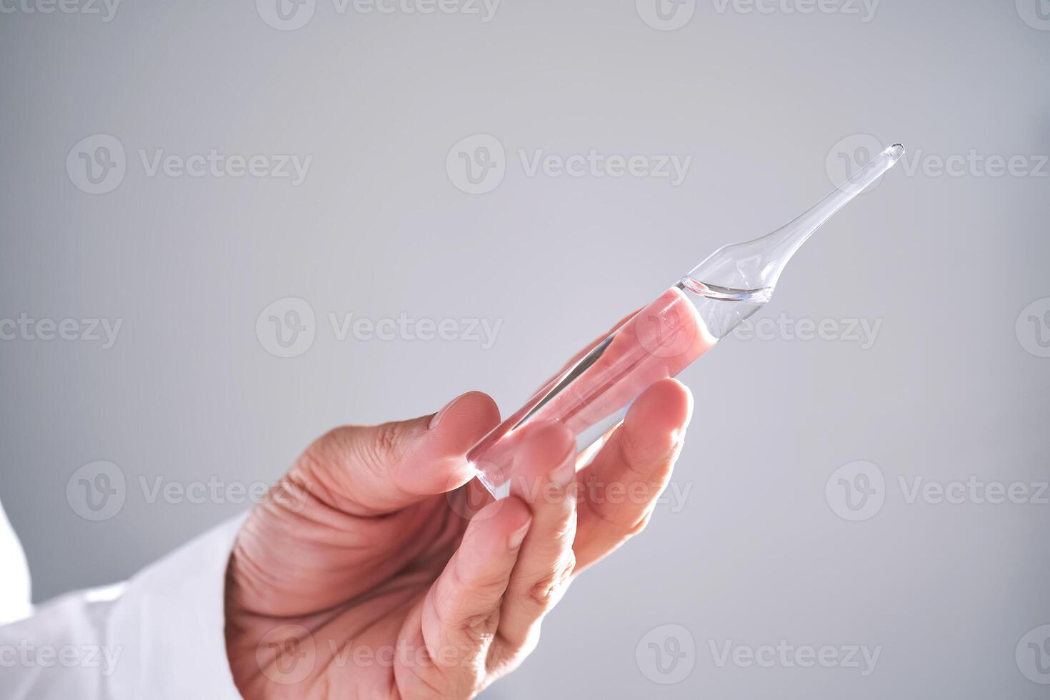 The doctor holds an ampoule with medicine. Close-up. photo