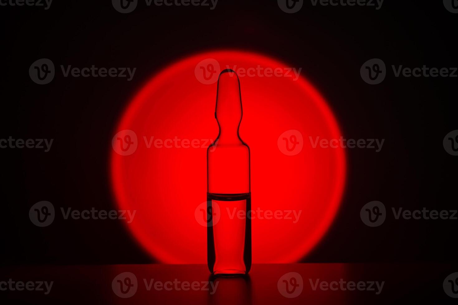 Ampoule for injection against the background of a bright red circle. photo