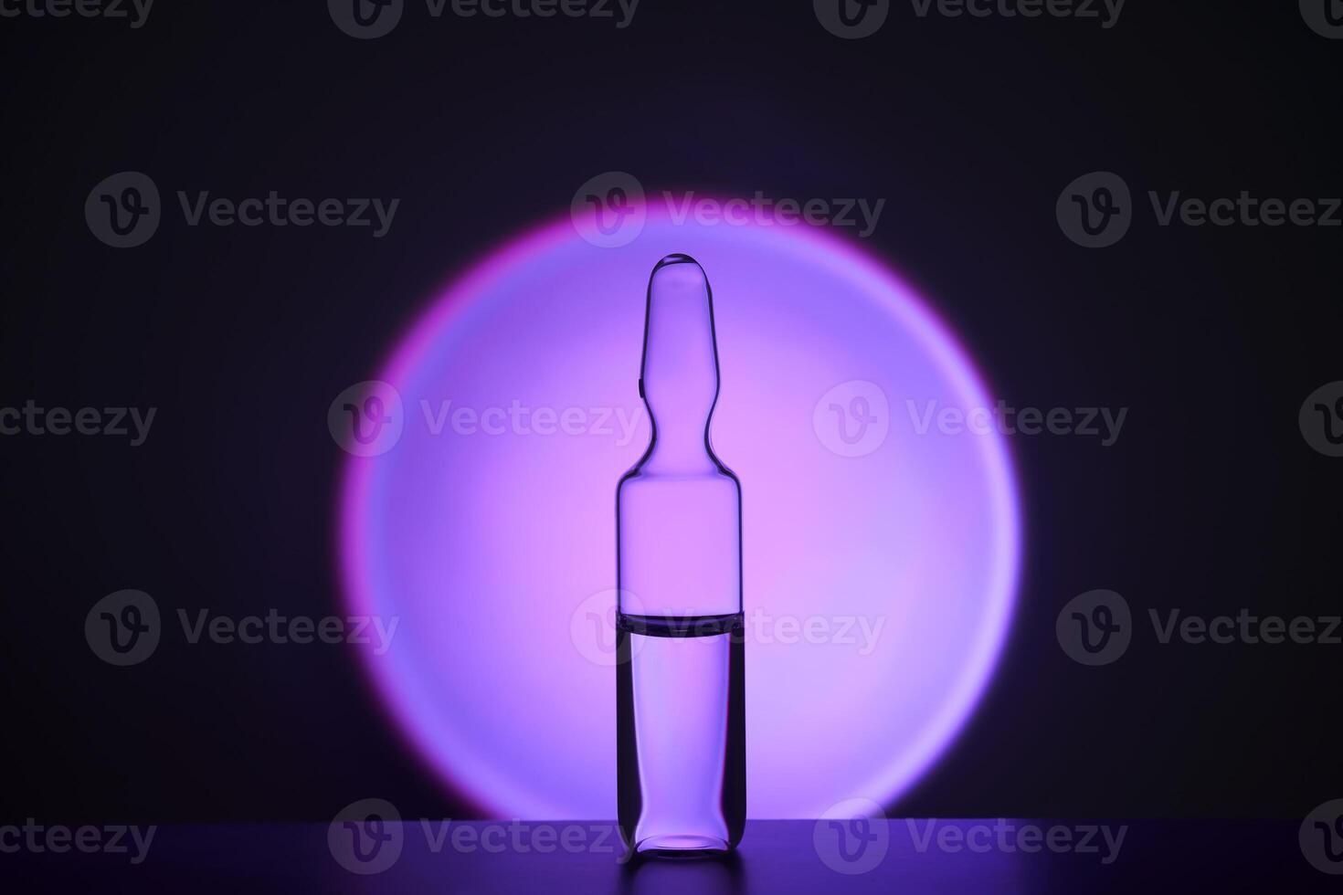 Several ampoules for injection with medicines on a lilac background. photo