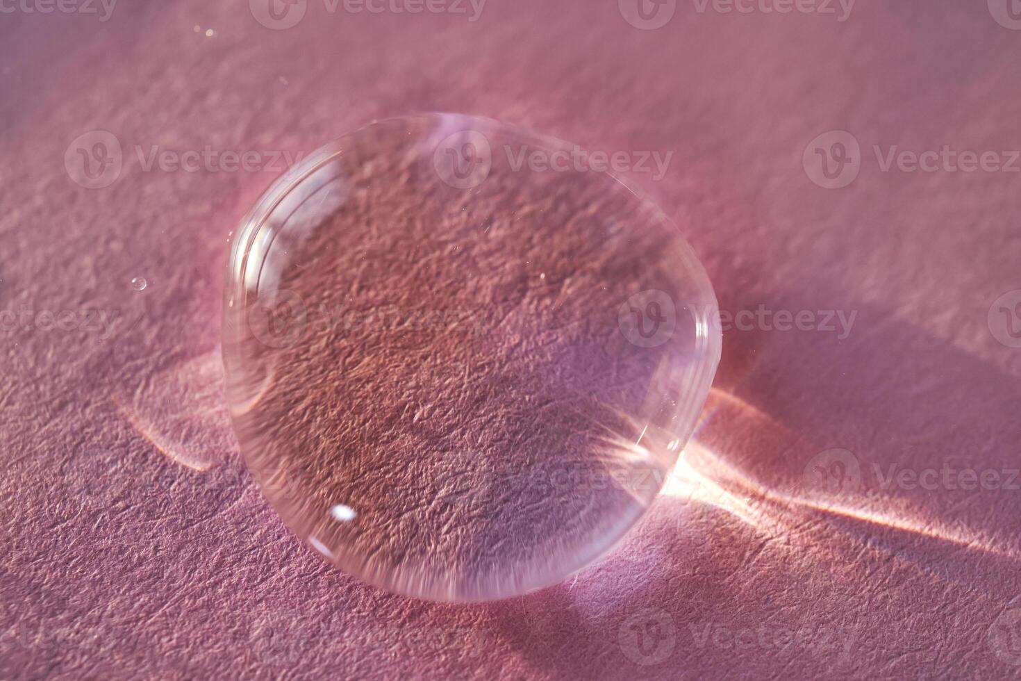 Beautiful volumetric drop of cosmetic product on a pink background. photo