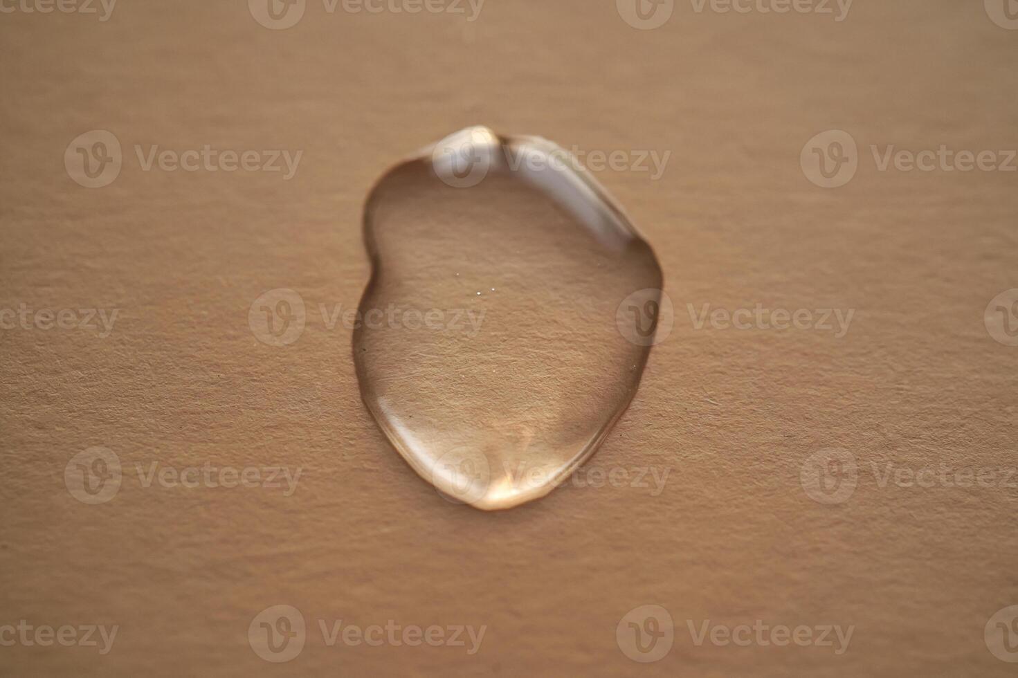 Beautiful volumetric drop of cosmetic product on a beige background. photo