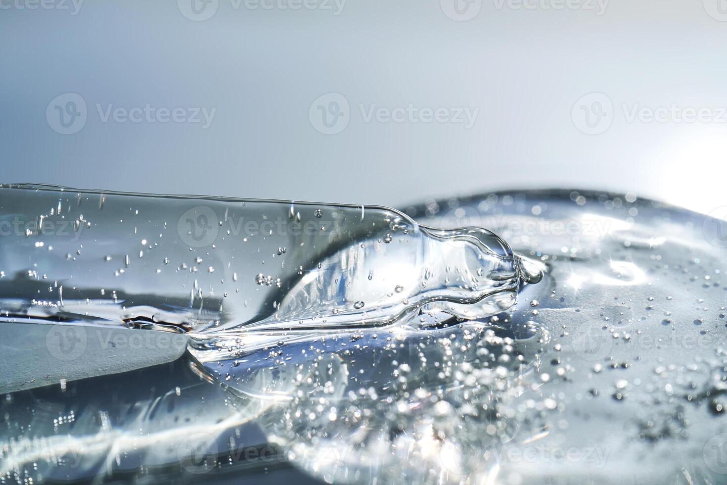Pipette with serum shimmering in the sun on a blue background. photo