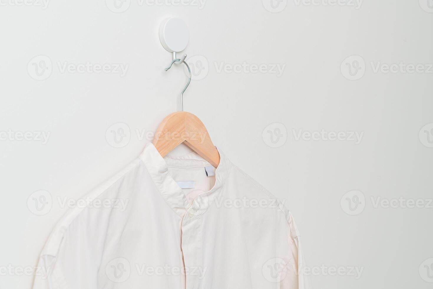 hanging shirt with wood hanger on wall photo
