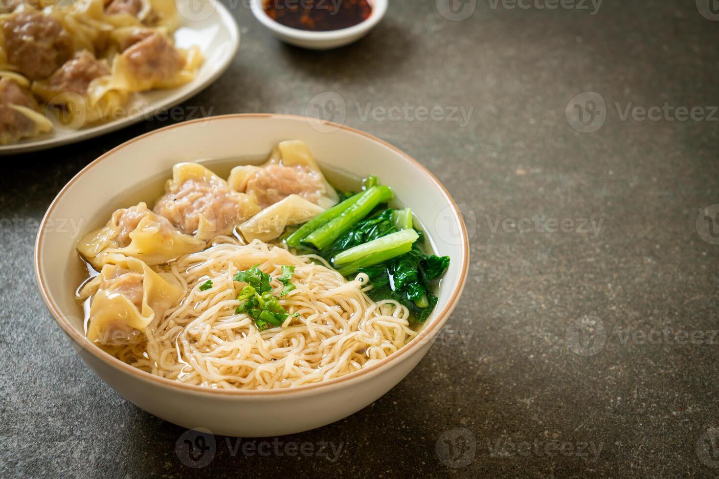 egg noodles with pork wonton soup or pork dumplings soup and vegetable photo