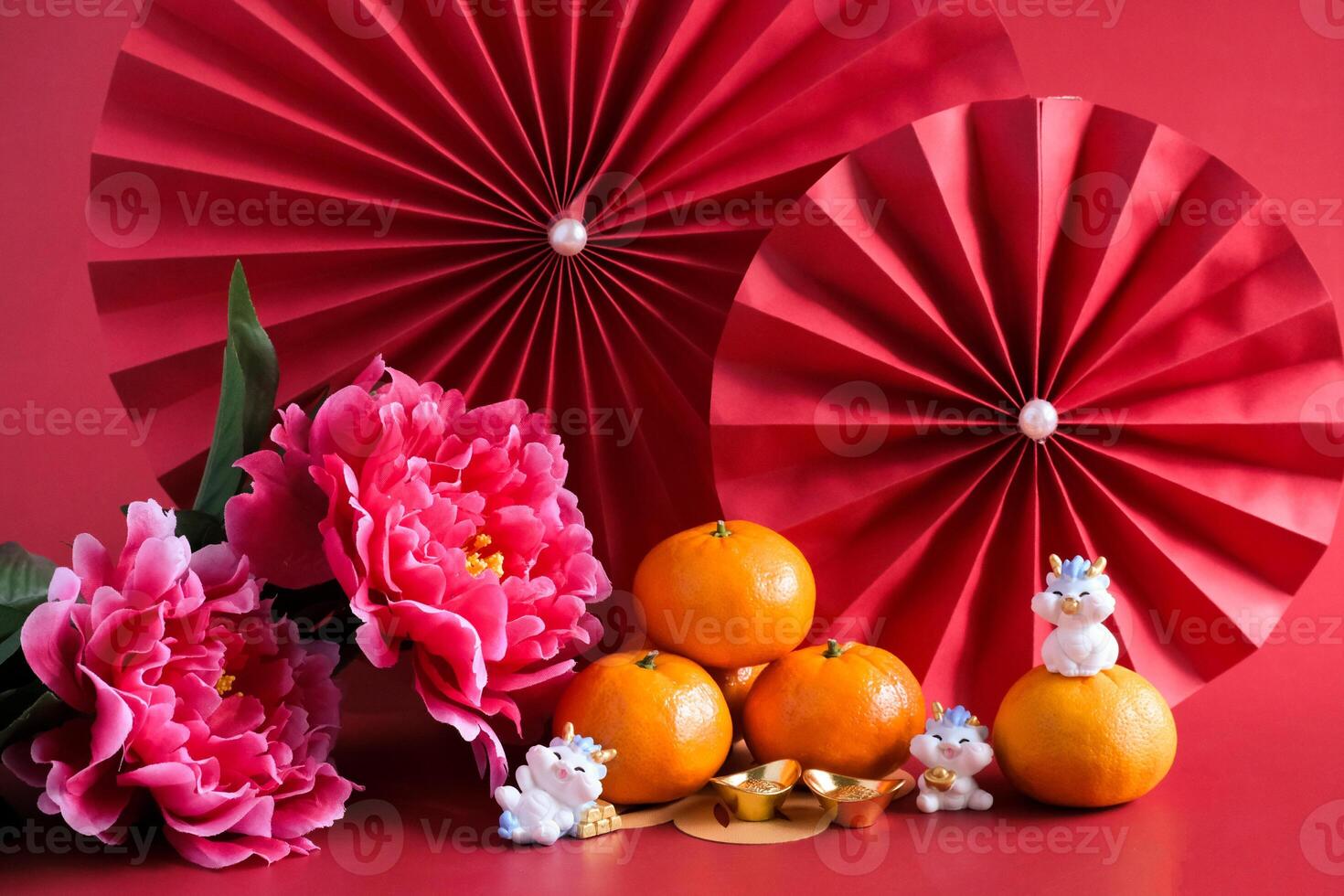 Chinese New Year of the dragon festival concept. Mandarin orange, red envelopes, dragon and gold ingot with red paper fans. Traditional holiday lunar New Year. photo