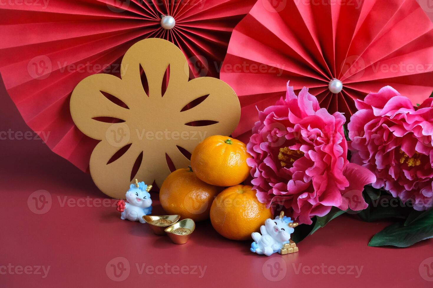 Chinese New Year of the dragon festival concept. Mandarin orange, red envelopes, dragon and gold ingot with red paper fans. Traditional holiday lunar New Year. photo
