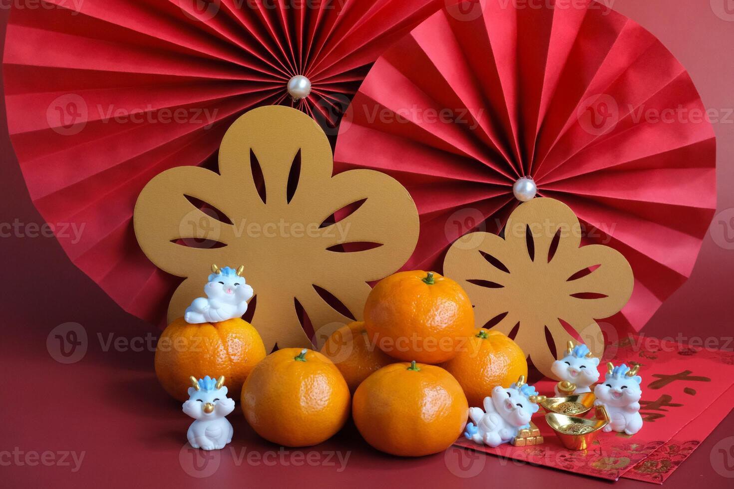 Chinese New Year of the dragon festival concept. Mandarin orange, red envelopes, dragon and gold ingot with red paper fans. Chinese character da ji da li meaning great luck great profit. photo