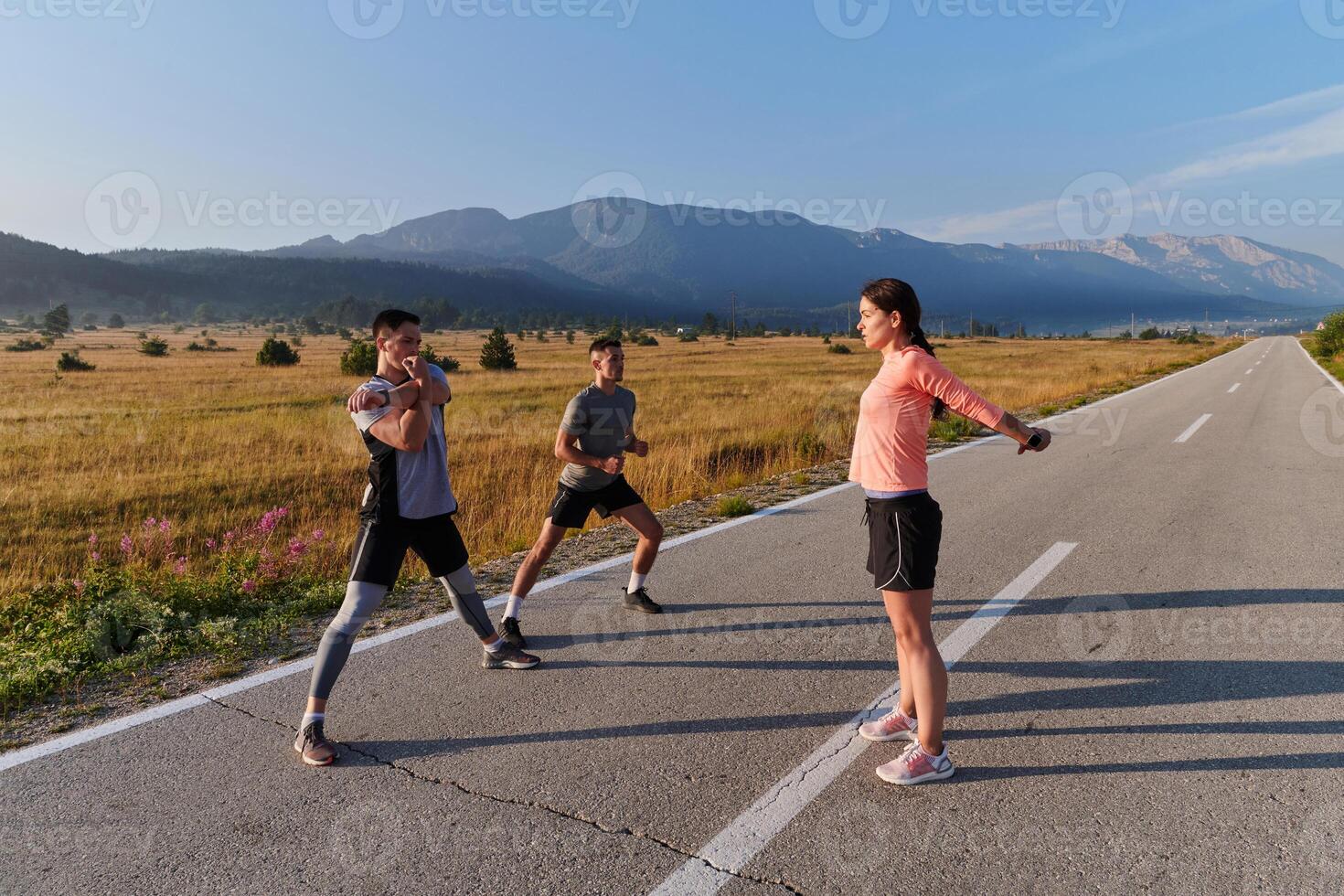 Diverse Athletes Prepare. Dynamic Group Warms Up for Morning Run. photo
