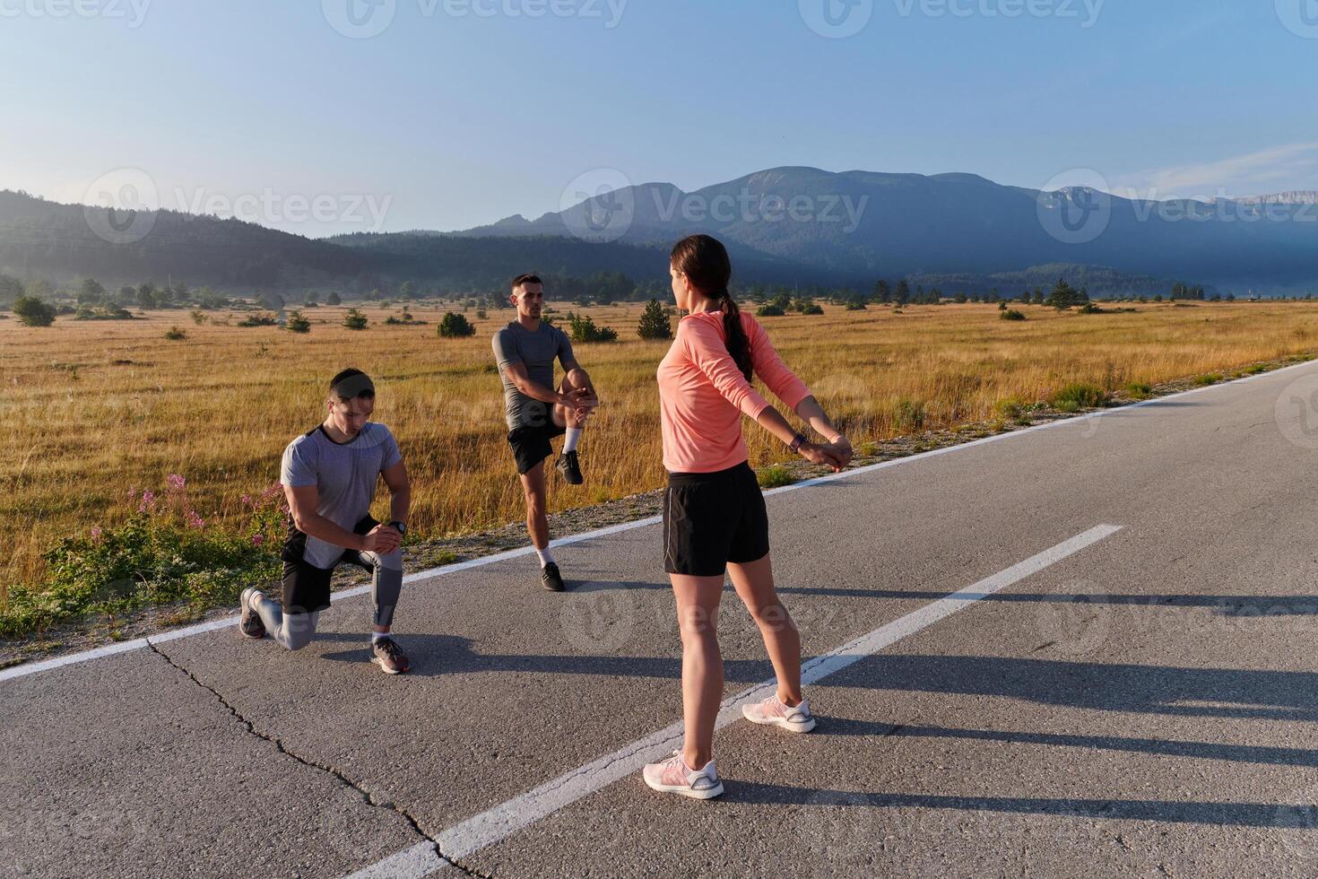 Diverse Athletes Prepare. Dynamic Group Warms Up for Morning Run. photo