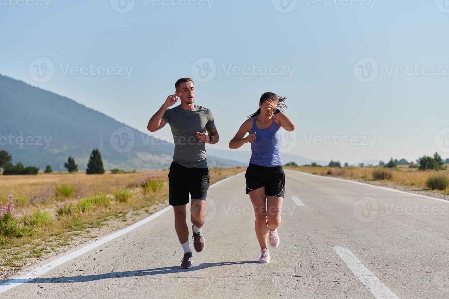 Energized by the beauty of nature, a couple powers through their morning run, their bodies and spirits invigorated. photo