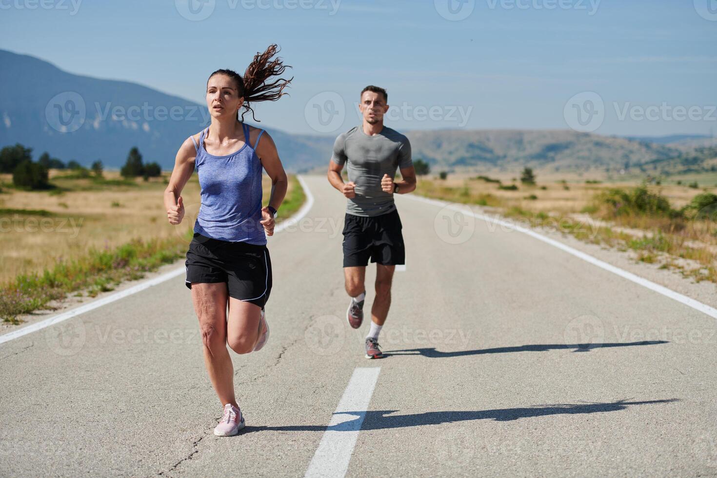 Energized by the beauty of nature, a couple powers through their morning run, their bodies and spirits invigorated. photo