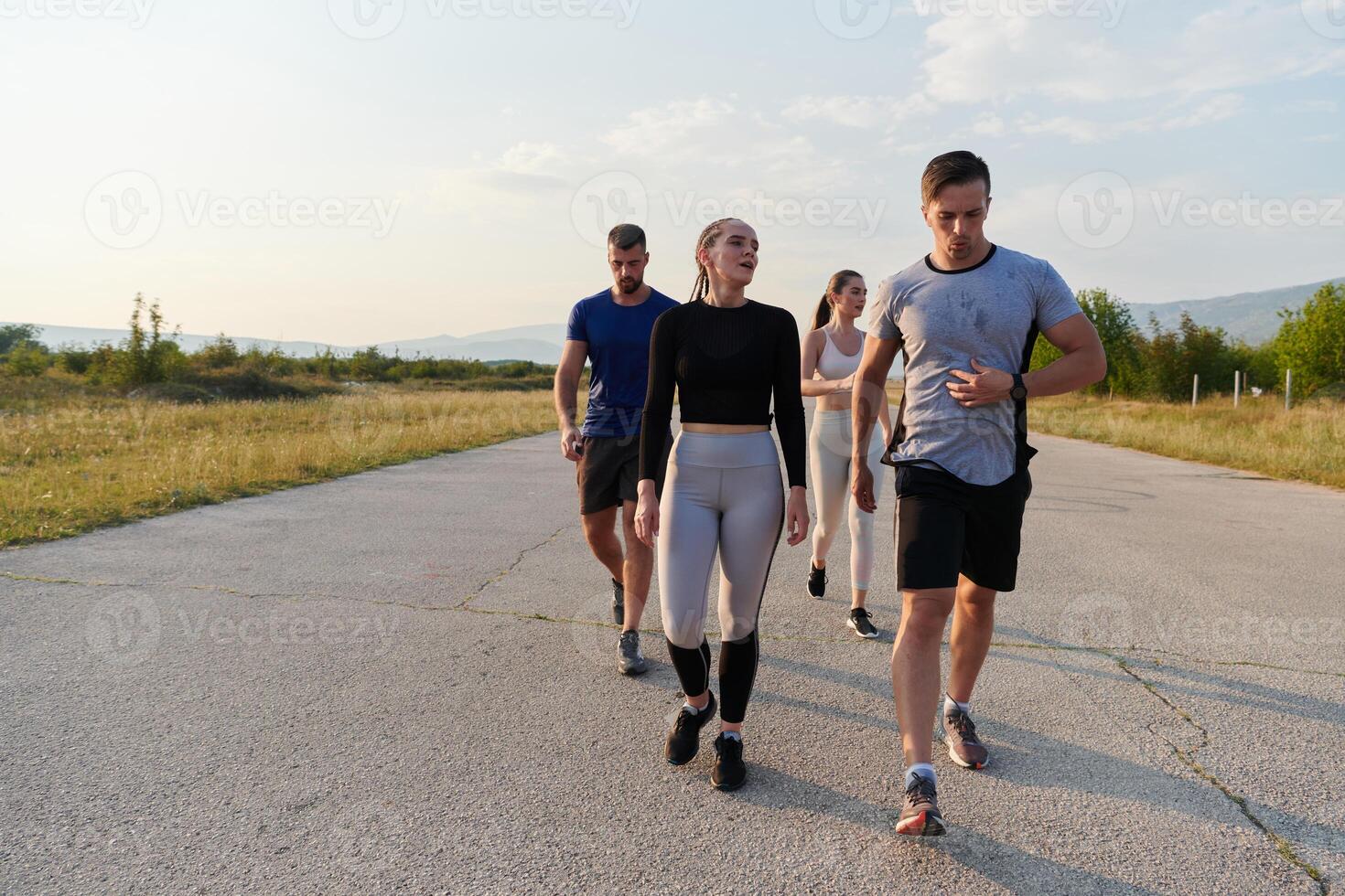 A group of friends maintains a healthy lifestyle by running outdoors on a sunny day, bonding over fitness and enjoying the energizing effects of exercise and nature photo