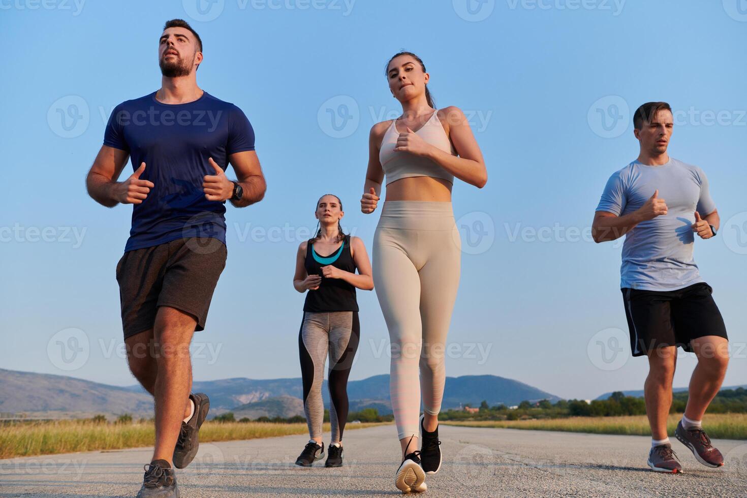 A group of friends maintains a healthy lifestyle by running outdoors on a sunny day, bonding over fitness and enjoying the energizing effects of exercise and nature photo
