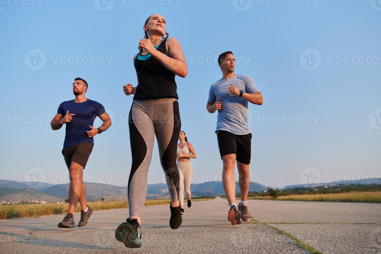 A group of friends maintains a healthy lifestyle by running outdoors on a sunny day, bonding over fitness and enjoying the energizing effects of exercise and nature photo