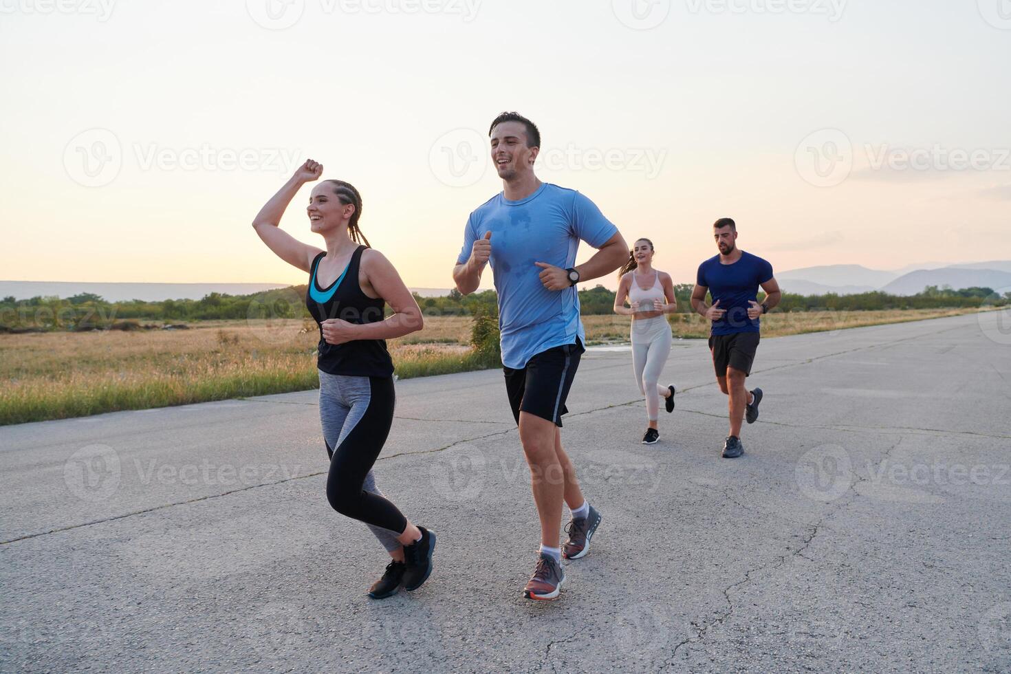 A diverse group of runners trains together at sunset. photo