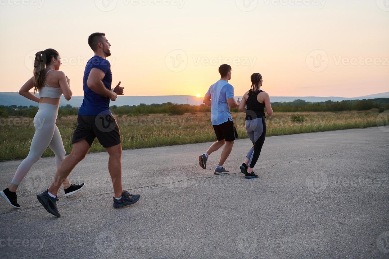 A diverse group of runners trains together at sunset. photo