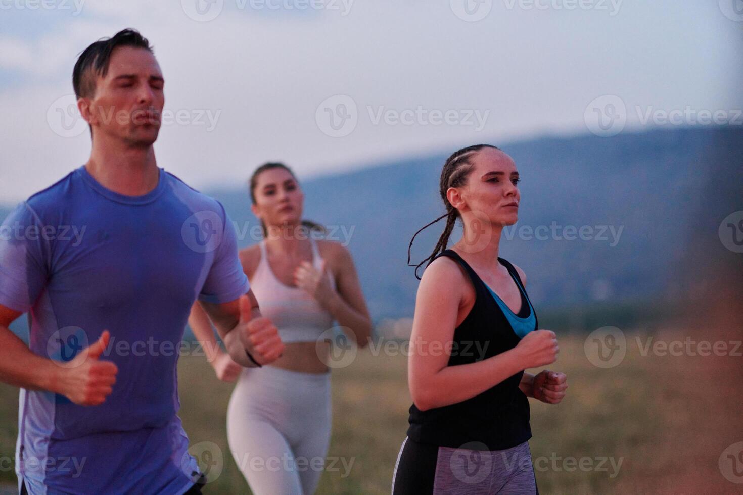 A diverse group of runners trains together at sunset. photo
