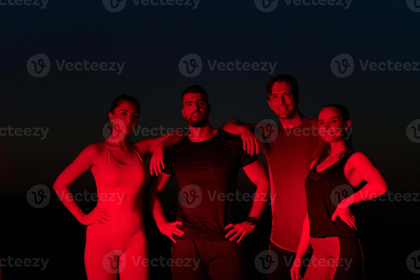 Diverse Athletes Unwind. Post-Marathon Rest Under Red Nighttime Glow. photo