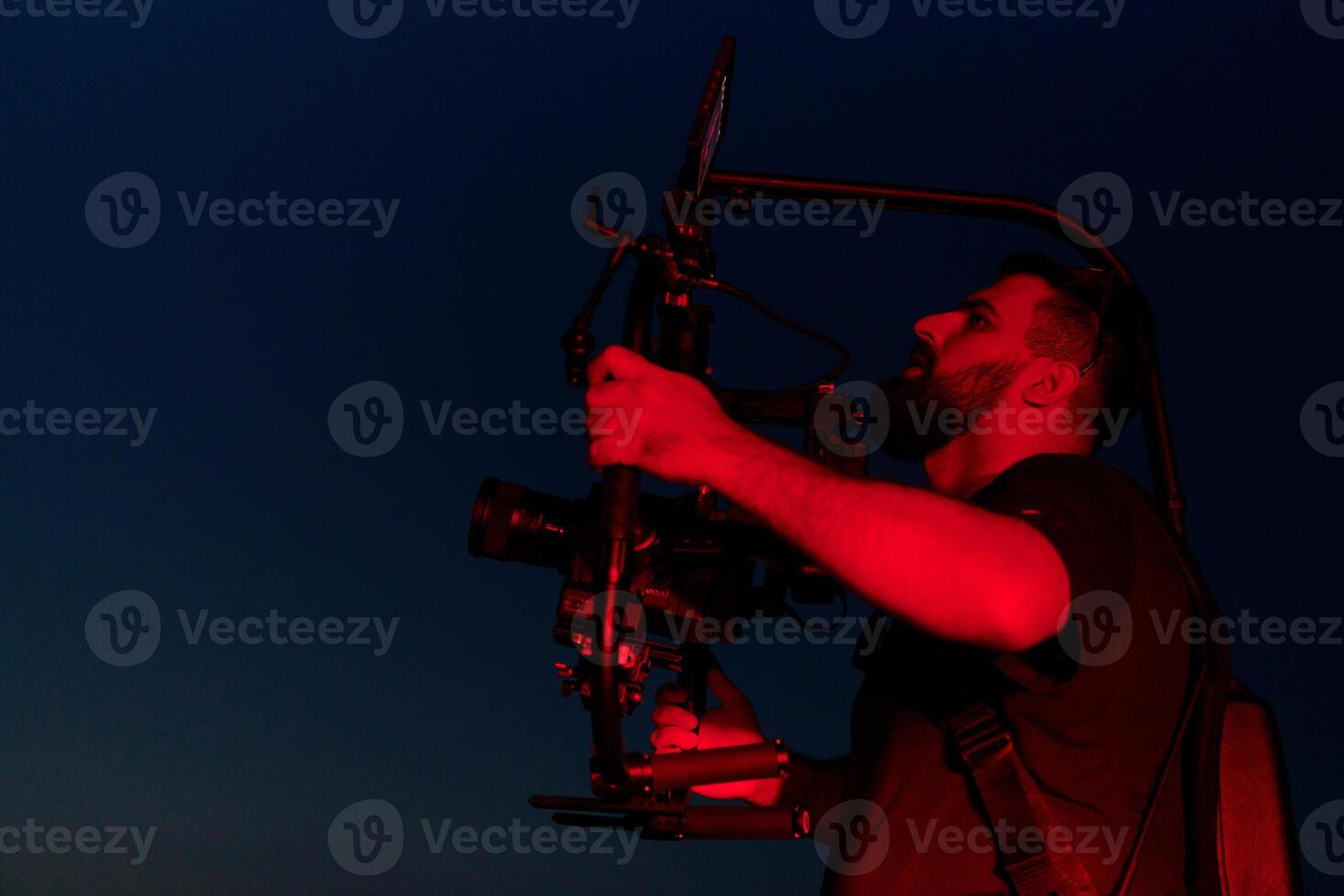 Nighttime Capture. Professional Videographer Films Athletes Running in Red-Lit Darkness photo