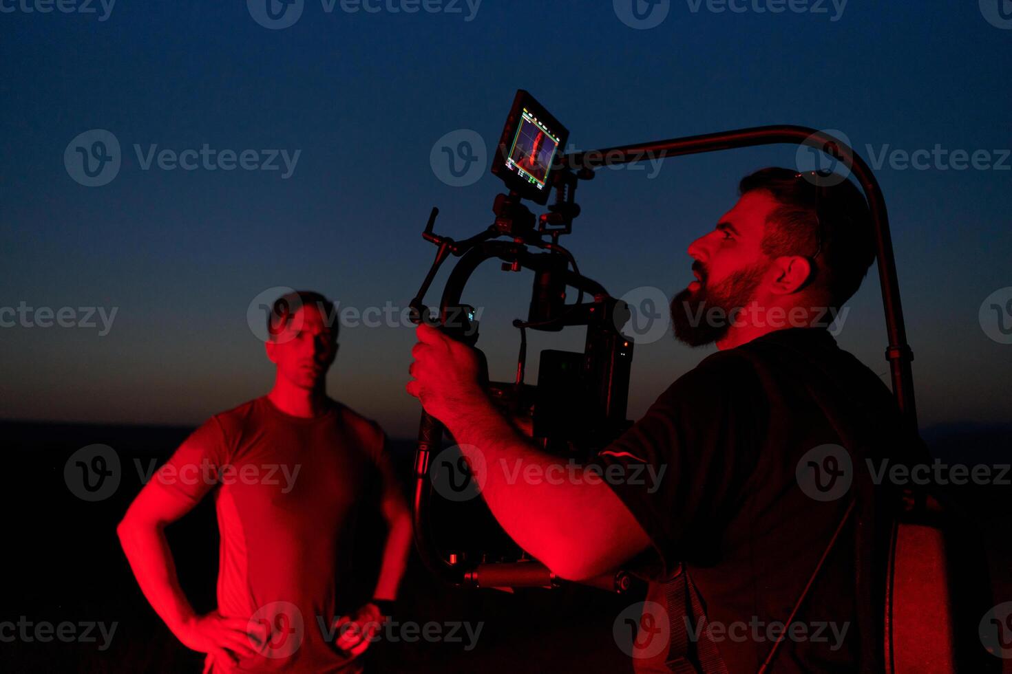 Nighttime Capture. Professional Videographer Films Athletes Running in Red-Lit Darkness photo