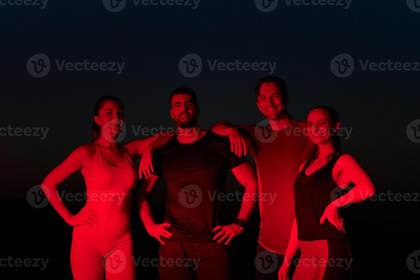 Diverse Athletes Unwind. Post-Marathon Rest Under Red Nighttime Glow. photo