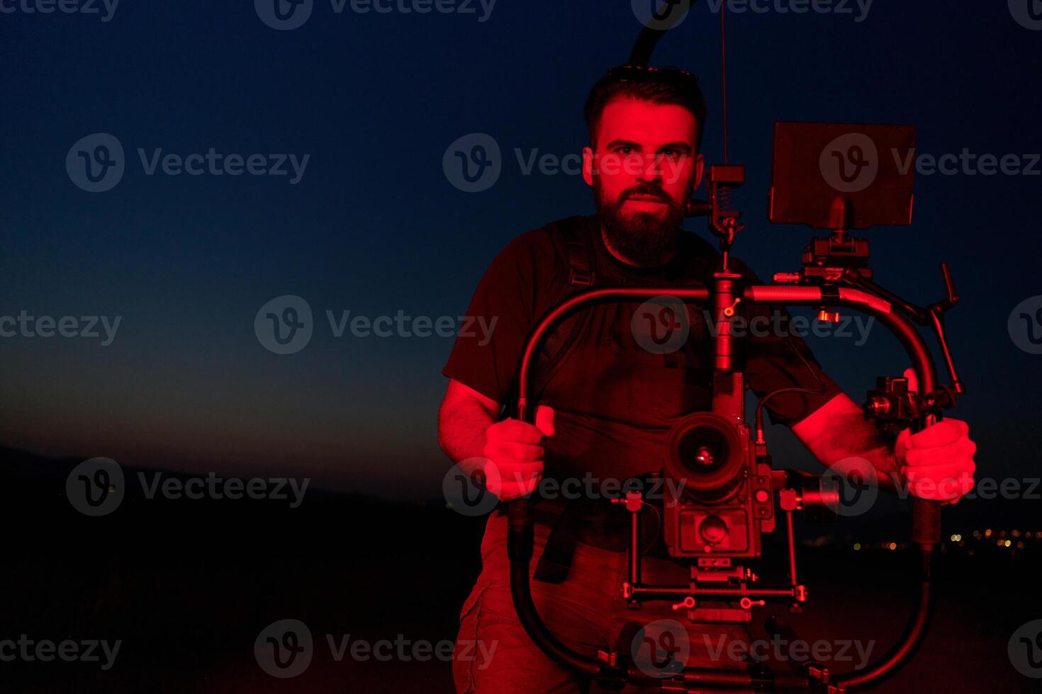 Nighttime Capture. Professional Videographer Films Athletes Running in Red-Lit Darkness photo