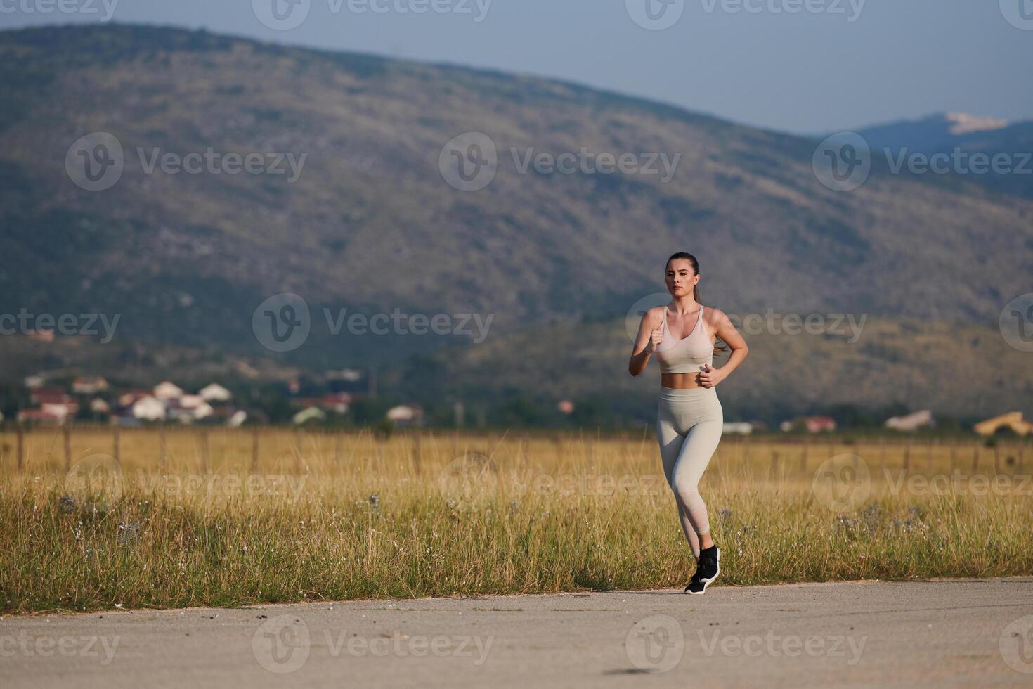 A determined woman athlete trains for success in the morning sun. photo