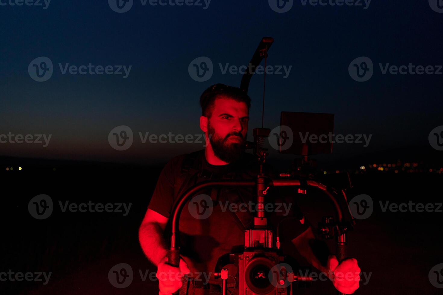 Nighttime Capture. Professional Videographer Films Athletes Running in Red-Lit Darkness photo