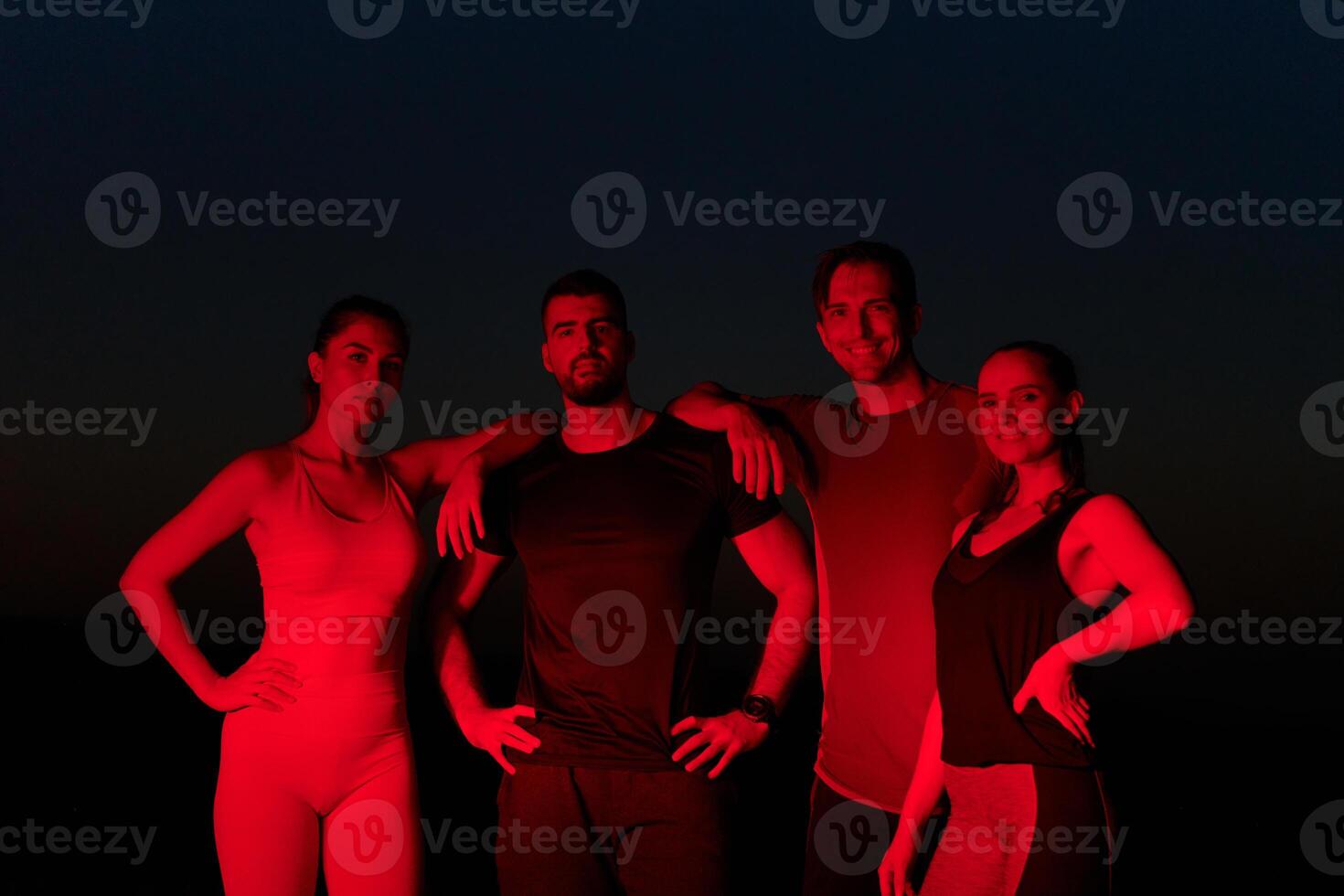 Diverse Athletes Unwind. Post-Marathon Rest Under Red Nighttime Glow. photo