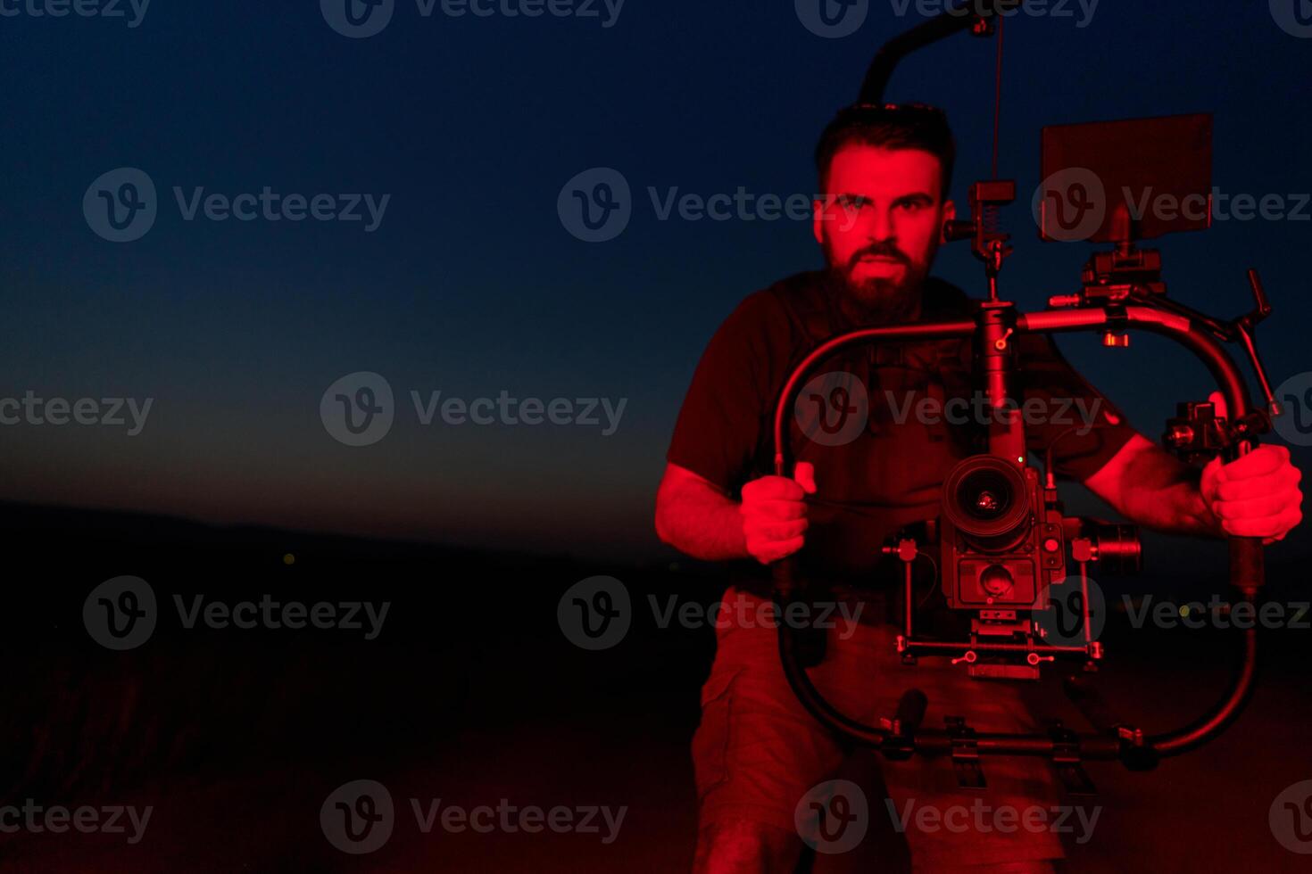 Nighttime Capture. Professional Videographer Films Athletes Running in Red-Lit Darkness photo