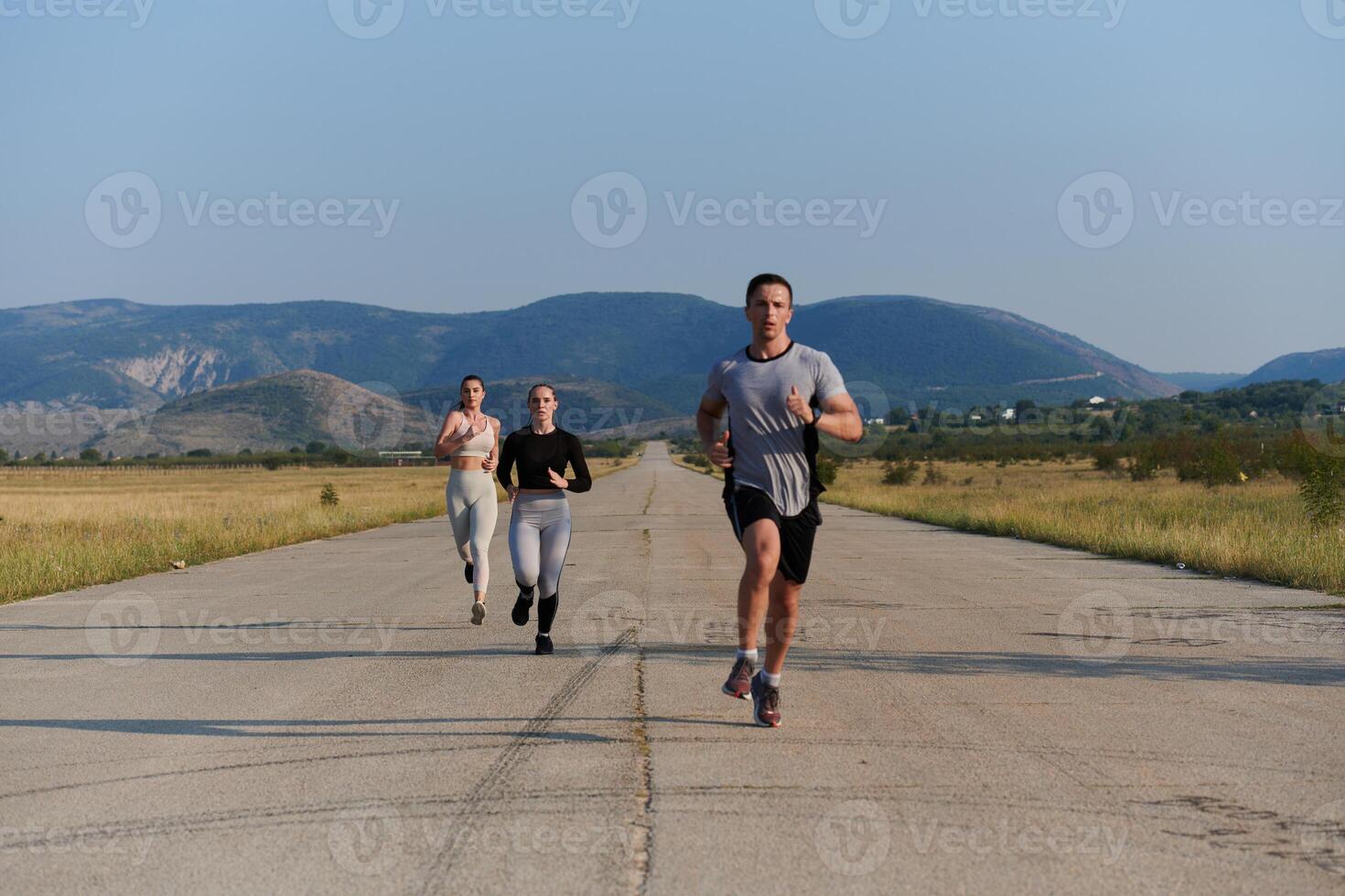 A group of friends maintains a healthy lifestyle by running outdoors on a sunny day, bonding over fitness and enjoying the energizing effects of exercise and nature photo