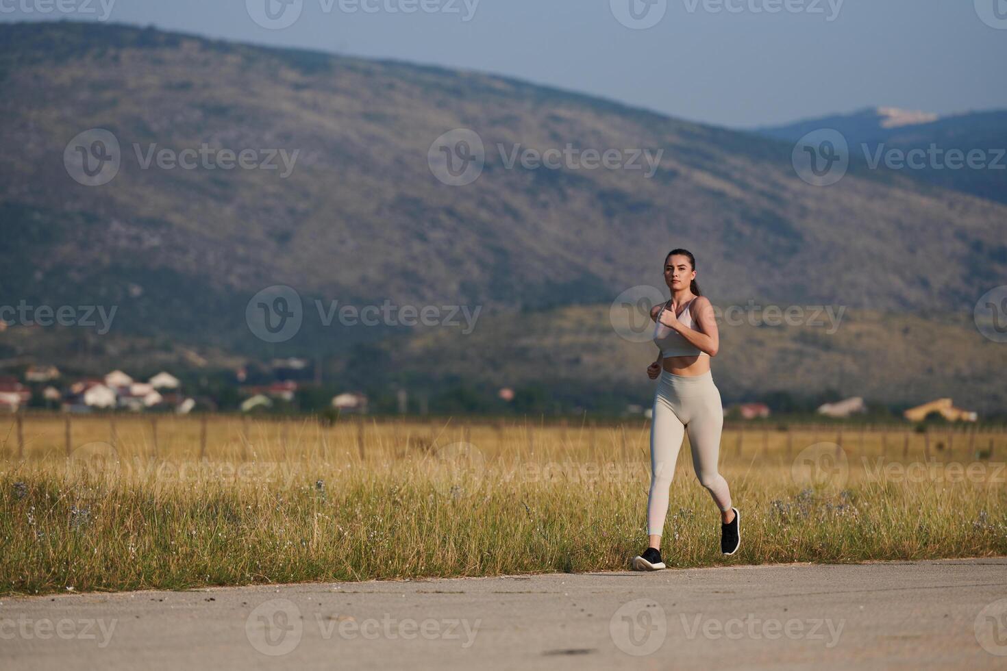 A determined woman athlete trains for success in the morning sun. photo