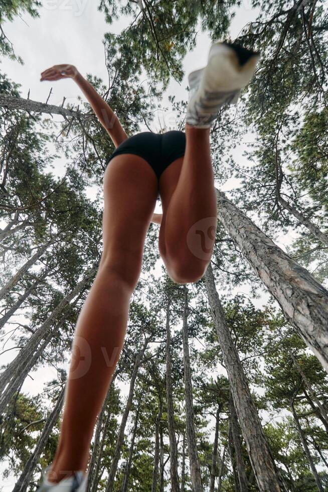 Adventurous Woman Overcoming Forest Obstacles with Determination and Agility. photo