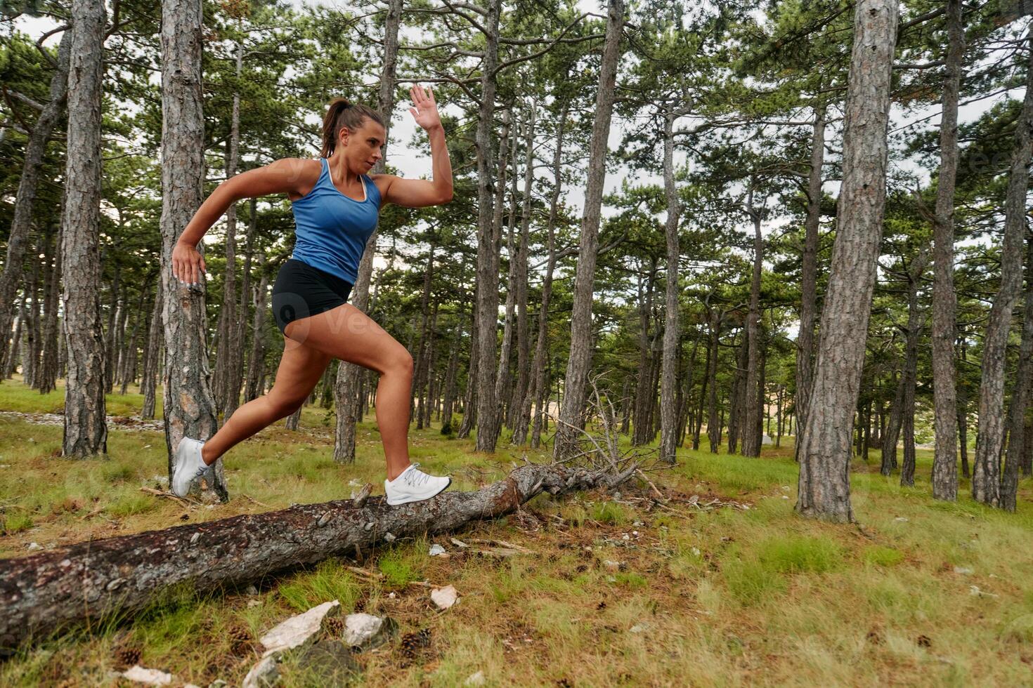 Fearless Woman Conquering Wooden Obstacles in the Dangerous Forest Terrain. photo