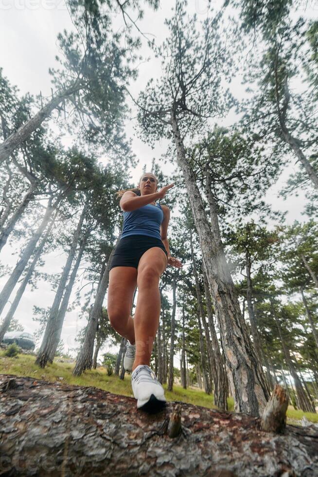 Adventurous Woman Overcoming Forest Obstacles with Determination and Agility. photo