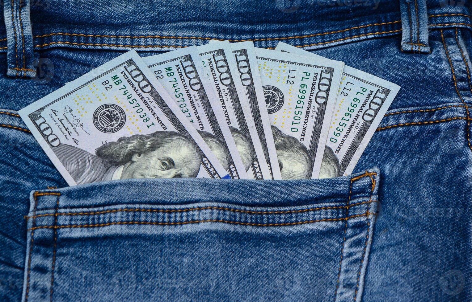 One hundred dollar banknote money in pocket jeans pants background texture. 100 dollar bill close up 1 photo