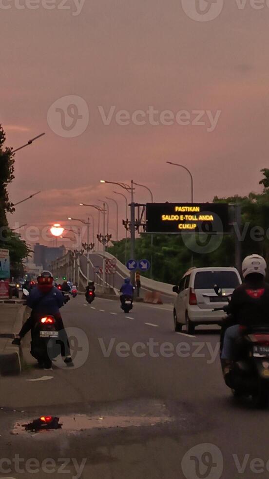 The atmosphere of a highway in the city with motorbikes and cars photo