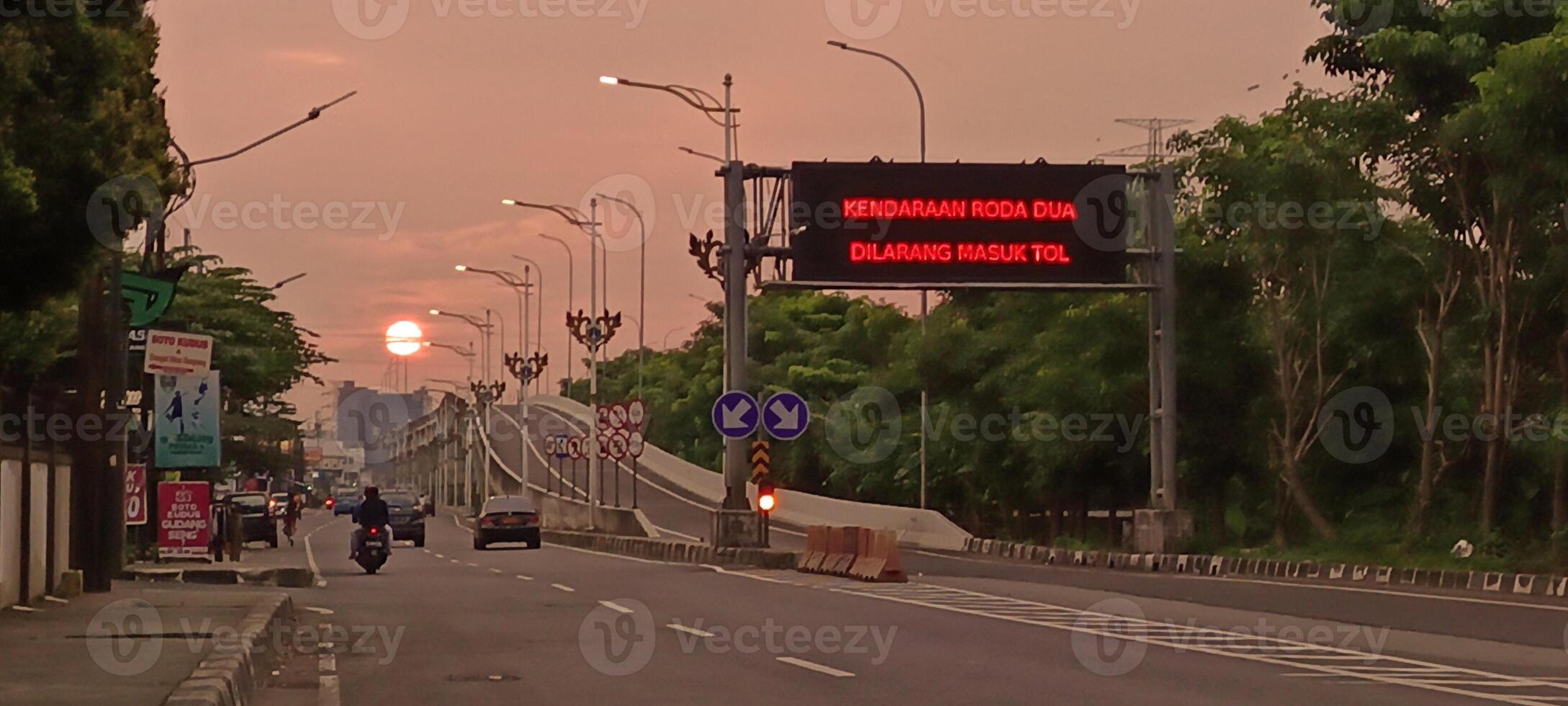 The atmosphere of a highway in the city with motorbikes and cars photo