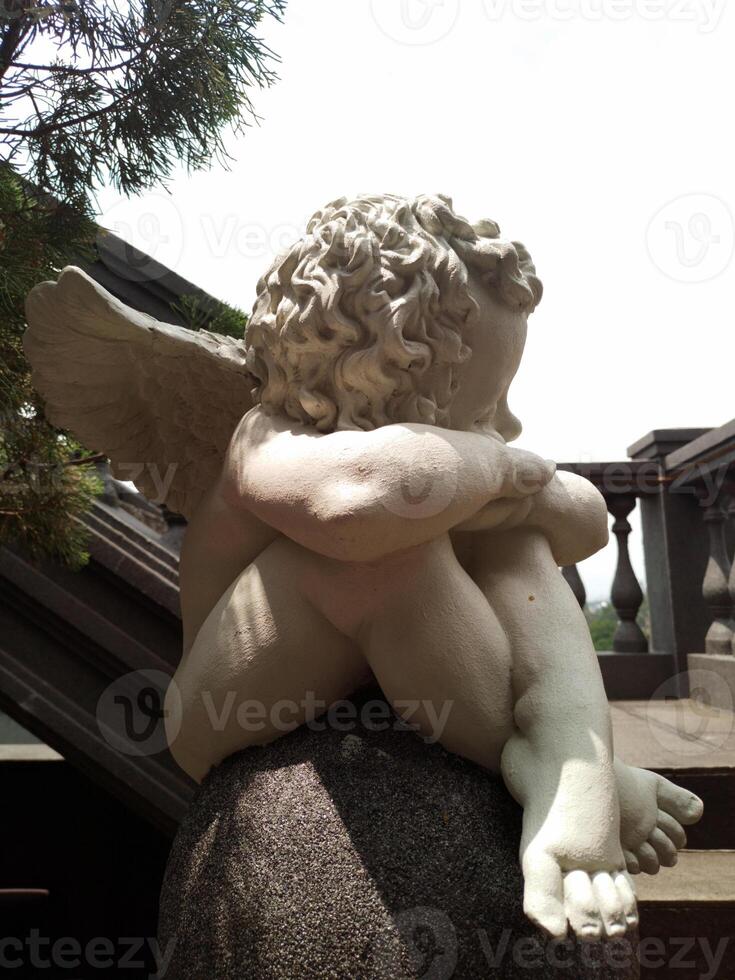 Statue of cute angel on the stairs photo