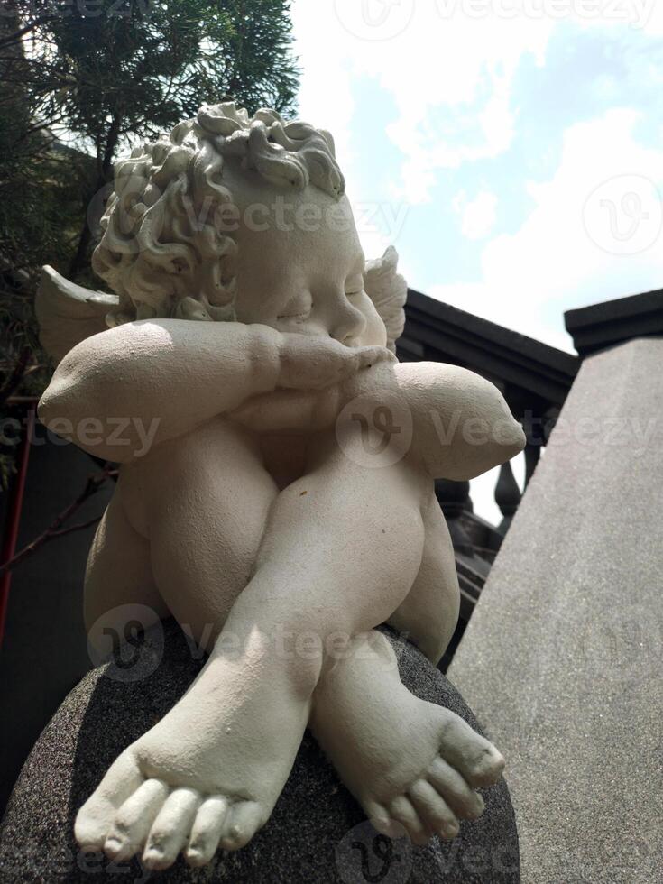 Statue of cute angel on the stairs photo