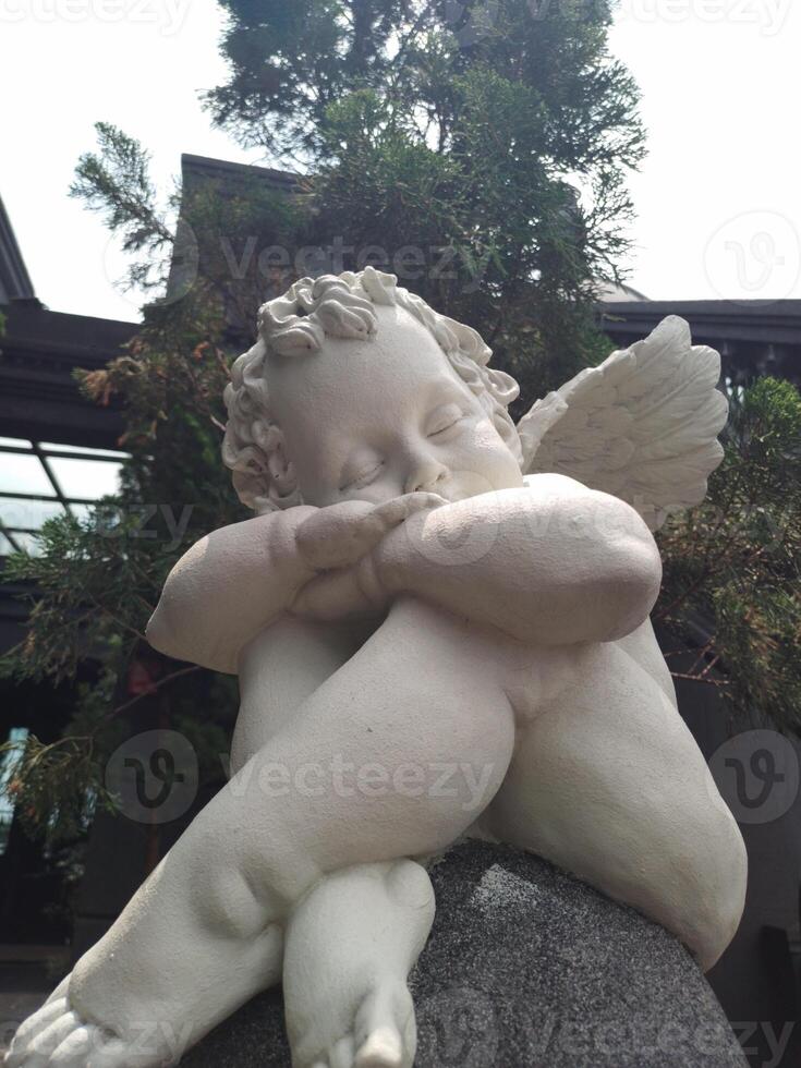 Statue of cute angel on the stairs photo