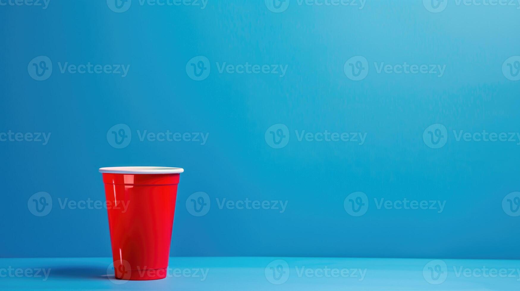 Minimalistic scene with a solo red plastic cup casting a soft shadow on a smooth blue surface photo