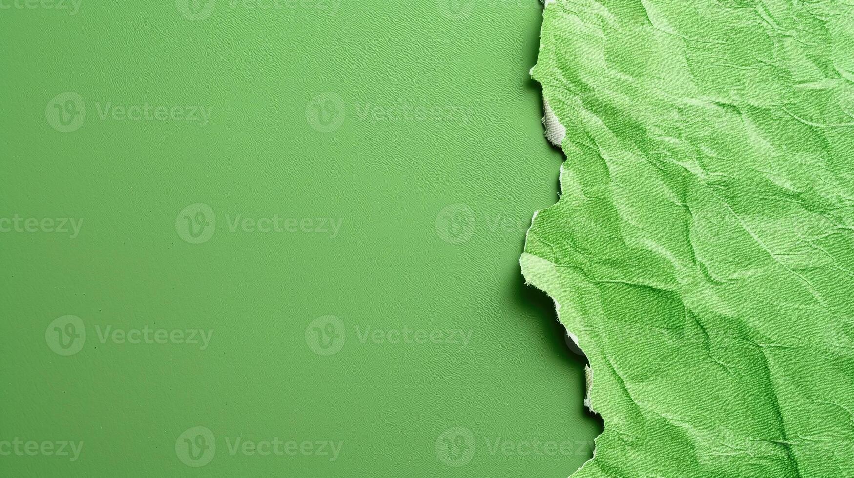 Textured green paper torn to reveal another layer, conveying a concept of change photo