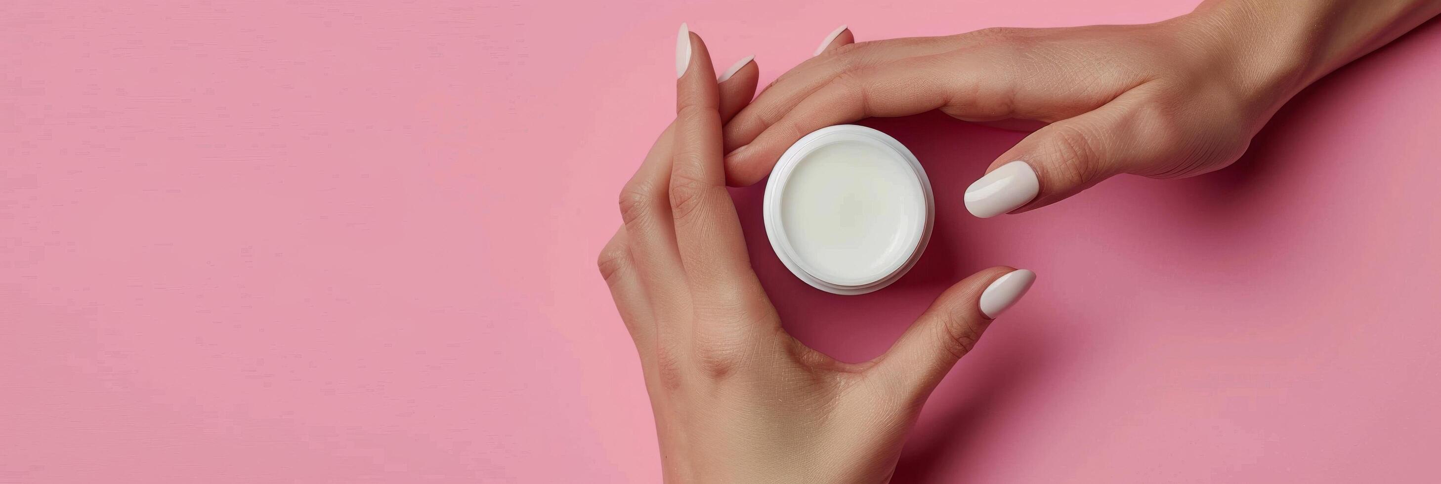 Womans Hands Holding Jar of Cream by Pink Flowers photo