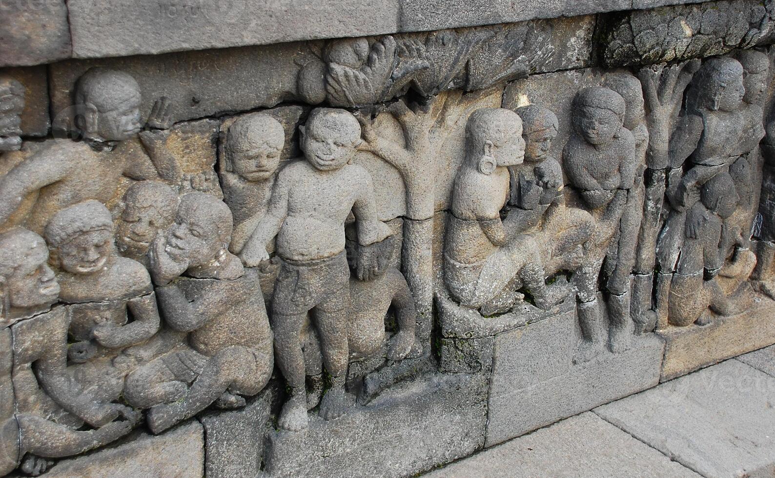 Bas-relief sculptures on wall at encased foot of Borobudur, Indonesia photo