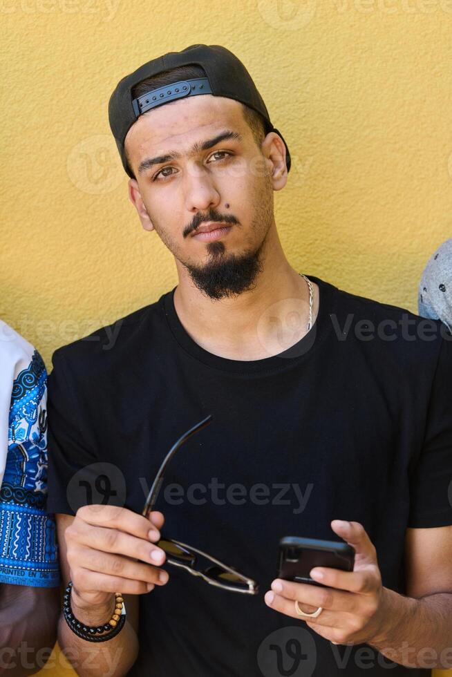 Close Up Portrait of Smiling Sudanese Teenager with Broad Smile, Chin, and Cap Using Smartphone photo