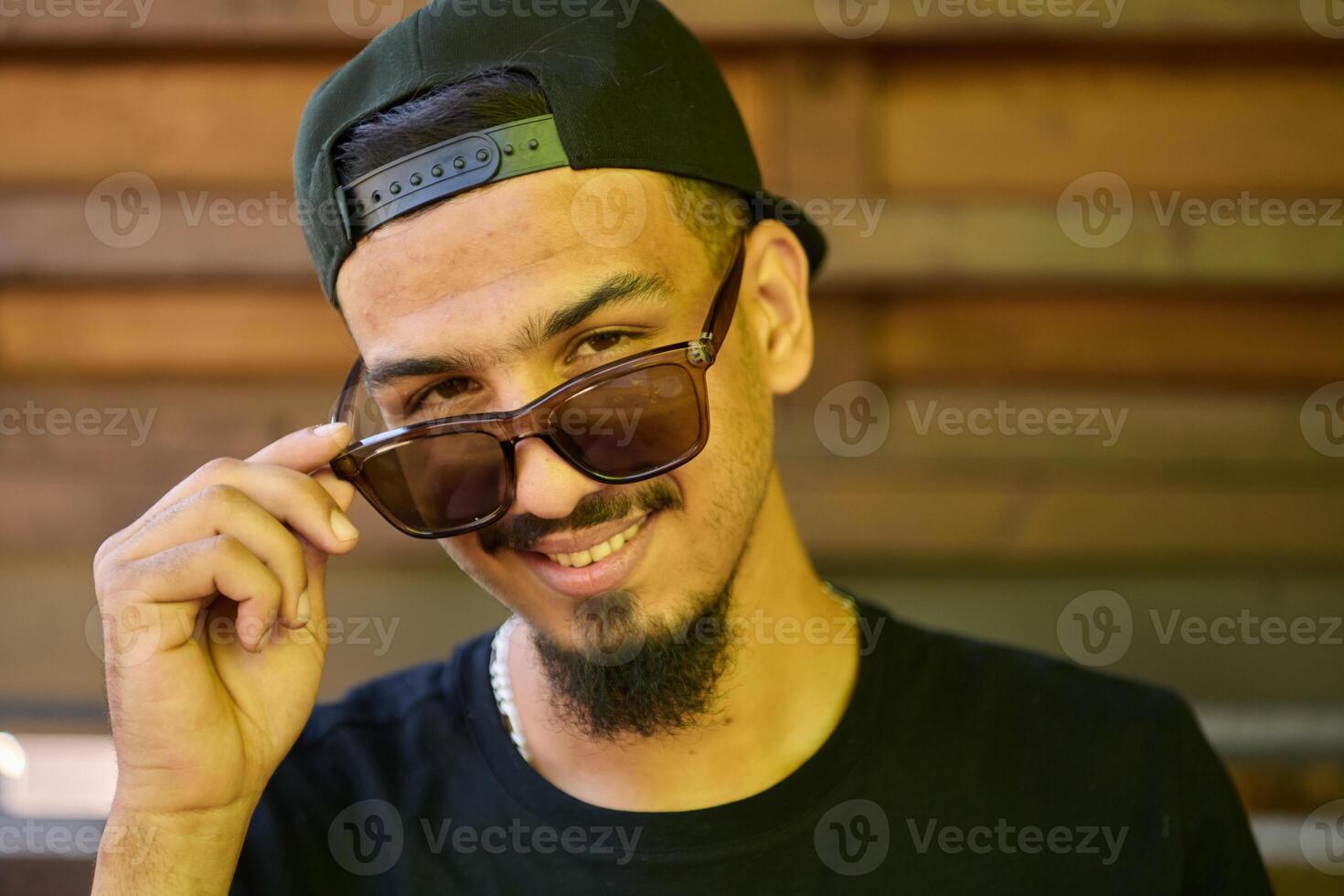 Close Up Portrait of Smiling Sudanese Teenager with Broad Smile, Chin, and Cap photo